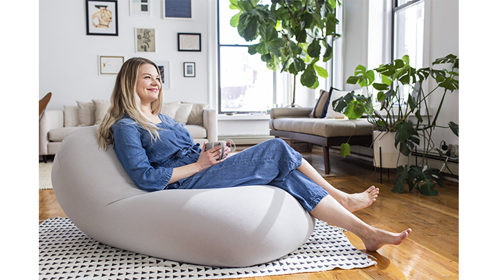 moon pod with woman reclining on it in a hygge background