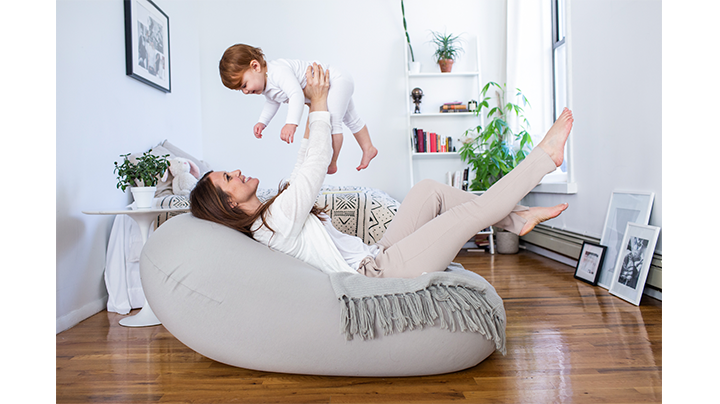 mother holding baby on moon pod laying back and relaxing